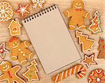 Blank notepad with christmas gingerbread cookies on wooden table