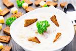 Delicious cheese soup with toasts in a white bowl