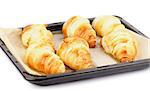 Freshly Baked Croissants on Black Oven with Parchment Paper isolated on white background
