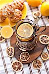 Black tea with lemon in the silver glass-holder with dry lemon around