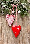 Christmas decoration with two hearts on an old wooden background with snow.