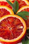 Sliced Sicilian blood red orange with leaf close up.
