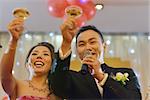 Natural candid photo Asian Chinese wedding dinner reception, bride and groom champagne toasting.