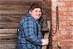 Happy overweight young man standing against a brick wall at the top of a stepladder laughing