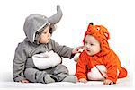 Two baby boys dressed in animal costumes playing over white