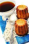 French small cake and cup of tea on a white background.