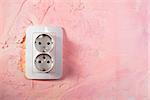 White socket on pink wall. Double socket