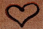Sign of a symbol of love - a heart in the form of a wet spot on black tissue of skin closeup