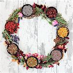 Medicinal herb selection also used in witches magical potions forming a wreath over distressed wooden  background.