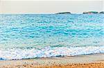 aqua turquoise sea rolls on the beach at dawn