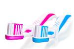 blue and pink toothbrushes lying on a white background