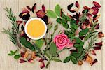 Honey, herb and rose flower ingredients for magical love potions over oak wood  background.