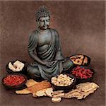 Chinese herbal medicine selection with buddha over handmade lokta paper background.