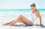 Smiling young woman sitting on beach