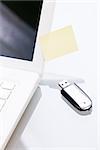 notebook laptop with post it memo and usb stick closeup macro objects office