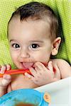 baby with his mouth open with spoon in hand