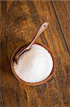 White sugar in a wooden bowl with a spoon.