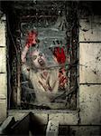 Photo of a hungry zombie covered with blood at the window.