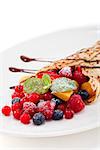 fresh tasty homemade crepe pancake with chocolate sauce fruits and berries