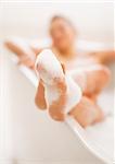 Closeup on legs of young woman in bathtub