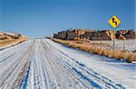 back country road over prairie in northern Colorado in winter scenery, a road sign with bullet holes