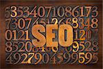 SEO (search engine optimization) acronym - letterpress wood type text against number background