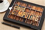 cloud computing - text in vintage letterpress wood type on a screen of digital tablet with a cup of coffee