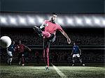 Soccer player kicking ball on field