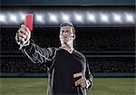 Referee flashing red card on soccer field