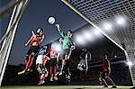 Soccer players defending goal