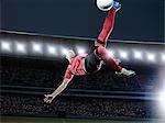 Soccer player kicking ball in mid-air on field