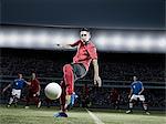 Soccer player kicking ball on field