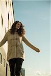 Teenage girl outdoors, standing next to building at loading dock, Germany