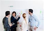 Group of young business people and mature businesswoman in discussion in office, Germany