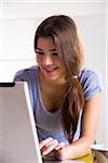 Close-up of young woman using laptop computer, working in office, studio shot