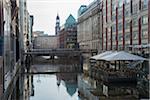 Canal with reflections of buildings on the water with a restaurant and umbrellas, in daylight, Hamburg, North Germany, Europe