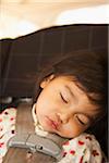 Close-up of toddler girl sleeping in child safety seat, USA