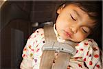 Close-up of toddler girl sleeping in child safety seat, USA