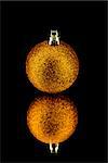 christmas decoration bauble in orange on black background