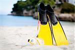 yellow fins and snorkelling mask on beach in summer holiday