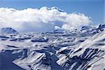 Snowy plateau and blue sky with clouds at nice evening. Caucasus Mountains, Georgia, view from ski resort Gudauri.