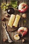 Delicious cheese on a rye bread with fruit and nuts on a wooden board.