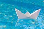 White paper boat floating in the water