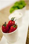 tasty tomatoes mazarella and basil on plate on wooden background