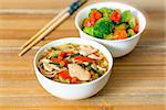 Bowls of Asian soup noodles and vegetables with Chopstick