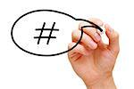 Hand sketching Hashtag Speech Bubble Concept with black marker on transparent wipe board.