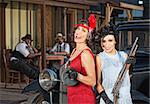 Pair of laughing 1920s gangster women with guns