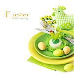 Easter table setting with chickeh candle and colorful eggs.