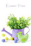 Easter decorations with green handmade chicken, colorful eggs  and watering can.