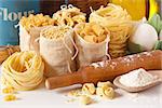 Assortment of pasta and wooden rolling pin close-up.